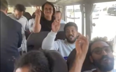 Activists from the intercepted Gaza-bound Global Sumud Flotilla flash victory signs as they are deported from Israel to Jordan via the Allenby Bridge crossing, in a video published October 7, 2025. (Screen capture: X/International Committee to Break the Siege of Gaza)